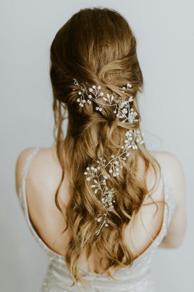 Back view of a woman with long brown hair and a delicate white hair accessory