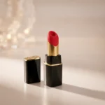 Womanizer Beauty Black/Gold clitoral stimulator with its protective cap placed beside the device.