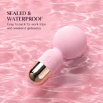 Blush pink mini wand vibrator resting in pink rippling water, illustrating its waterproof design
