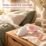 Coco Seed white and blush pink vibrator resting on linen, showing its magnetic charging contacts