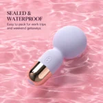 Lilac purple mini wand vibrator resting in pink rippling water, illustrating its waterproof design