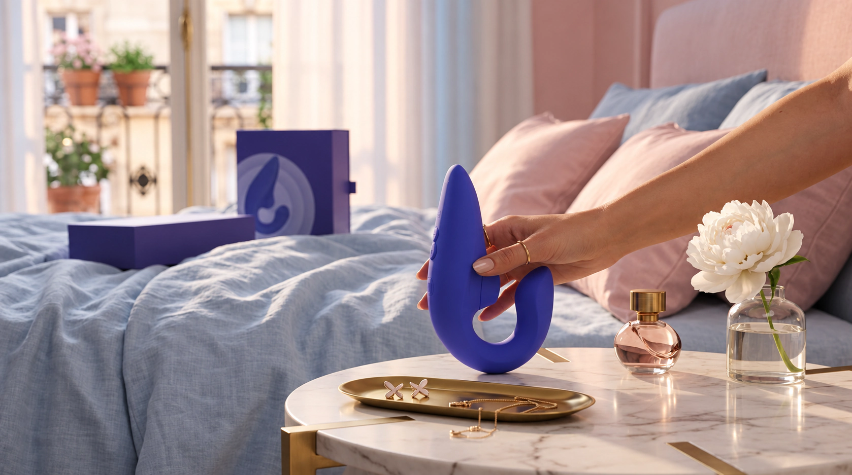 Womanizer Blend held beside a bedside table in a pink and blue bedroom